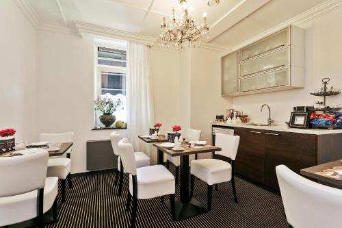 Eefde阿丽萨别墅哈尔尼酒店的一间带桌子和白色椅子的用餐室