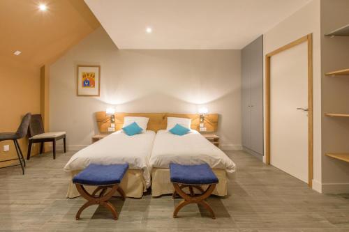 圣拉里苏朗Casa Mir的一间卧室配有一张床和两张蓝色椅子