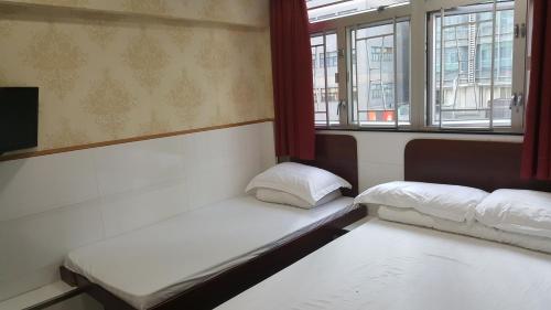 香港龙华賓館的配有窗户的客房内的两张床