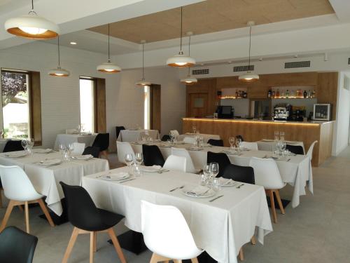 卡萨拉雷纳Hotel Entrerailes的用餐室配有白色的桌子和白色的椅子