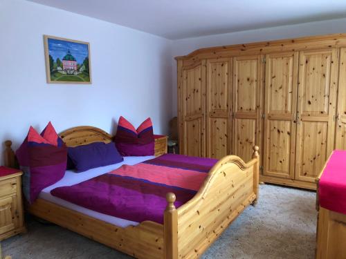 拉德博伊尔Fewo Radebeul Altkötzschenbroda的一间卧室配有一张木床和木柜