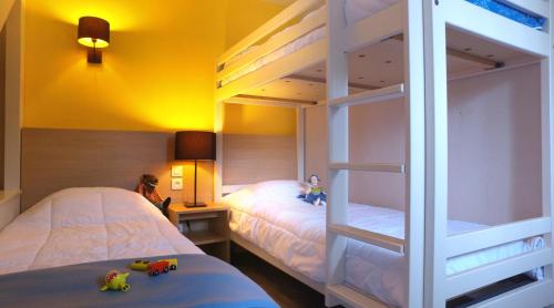 圣拉里苏朗VVF Saint-Lary-Soulan Hautes-Pyrénées的一间卧室配有两张双层床,床上有娃娃