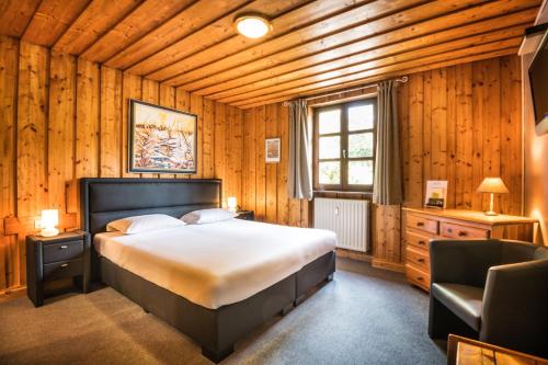 阿瑟尔博恩多迈纳都穆林达瑟尔博恩酒店的木制客房内的一间卧室,配有一张床