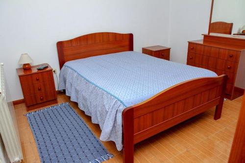 塞亚Hospedaria Santa Cruz的一间卧室配有木床和2个床头柜