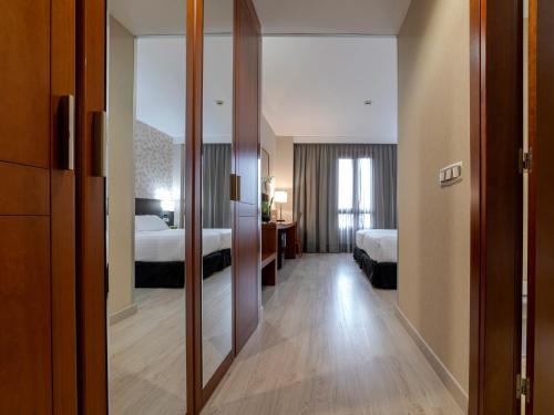 拉斯·罗萨斯·德·马德里拉斯麦塔斯广场酒店的酒店客房,设有两张床和镜子