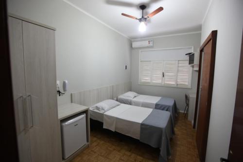 LeopoldinaHOTEL ALVORADA的小房间设有两张床和吊扇