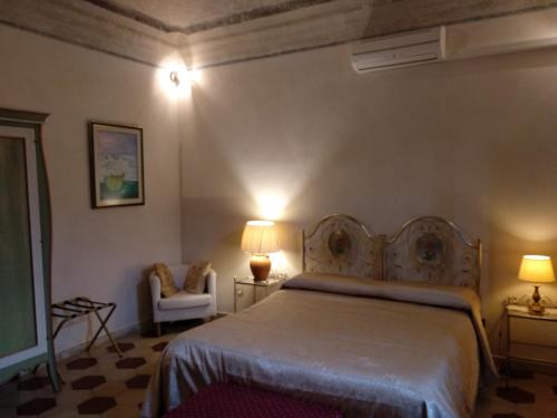 圣朱利亚诺-泰尔梅克里布住宿加早餐酒店的一间卧室配有一张床、椅子和灯具