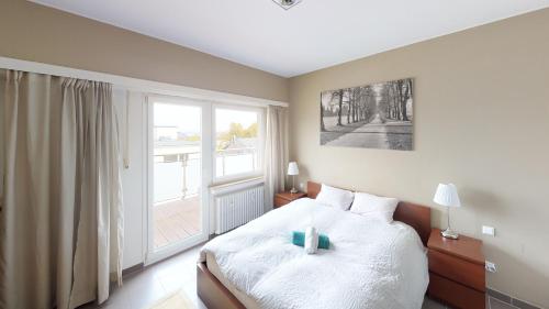 卢森堡2 Bedroom Penthouse in Gasperich的一间卧室设有一张床和一个大窗户