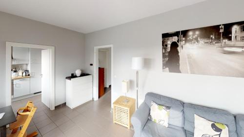 卢森堡2 Bedroom Penthouse in Gasperich的客厅配有沙发和墙上的照片