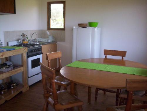 科金博cabañas sector peñuelas的厨房配有桌子和白色冰箱。