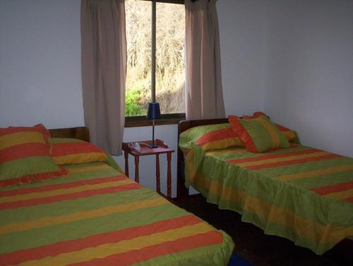 科金博cabañas sector peñuelas的带窗户的客房内的两张床