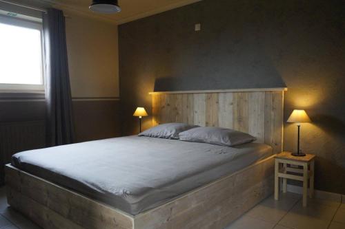 马塞克Kampenhof的一间卧室配有一张大床和木制床头板