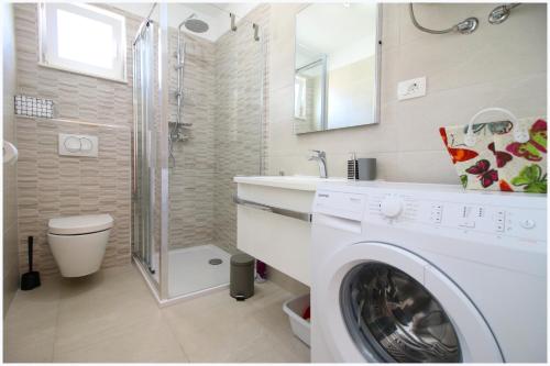 罗戈兹尼察Apartments Silver Beauty的带淋浴的浴室内的白色洗衣机