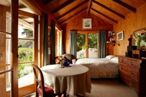 科灵伍德Te Hapu Coastal Cottages的卧室配有一张床和一张桌子