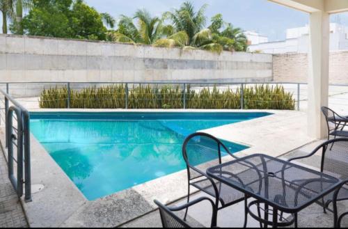 比亚埃尔莫萨Suites Real Tabasco的一个带椅子和桌子的游泳池
