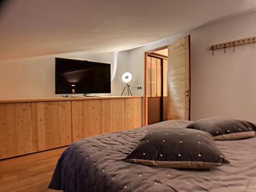 蒙热内夫尔La Durance的一间卧室设有一张带平面电视的床。