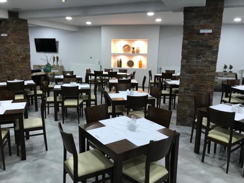 卡拉维塔Filoxenia Hotel & Spa的一间在房间内配有桌椅的餐厅