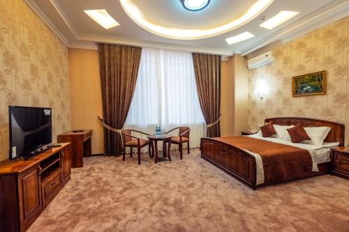 撒马尔罕Meros Boutique Hotel的酒店客房配有一张床铺和一张桌子。