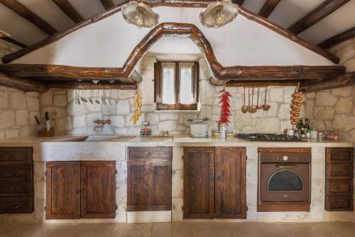 切列梅萨皮卡Trullo Dei Messapi的一个带木制橱柜和水槽的大厨房