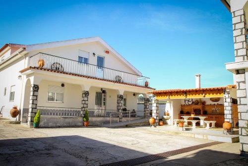塞亚Hospedaria Santa Cruz的大型白色房屋设有阳台和庭院。