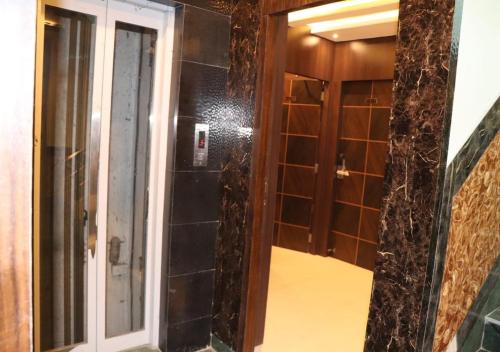 加尔各答Hotel Angina的带淋浴的浴室和玻璃门