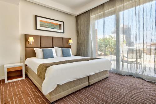 圣朱利安斯乔治城市精品酒店 的一间卧室设有一张大床和一个大窗户
