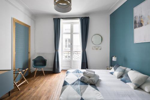 南特Le Prestige by Cocoonr的一间卧室配有一张带蓝色墙壁的大床