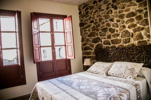 里瓦达维亚A casa da Igrexa的一间卧室设有一张床和石墙