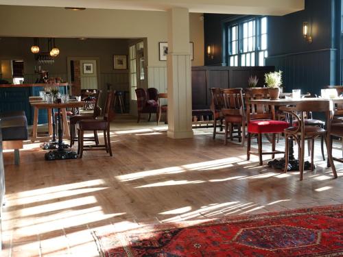达灵顿The Devonport的用餐室配有木桌和椅子,阳光充足