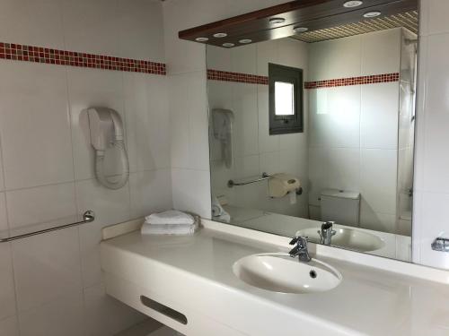 勒拉芒坦Hotel La Galleria的白色的浴室设有水槽和镜子