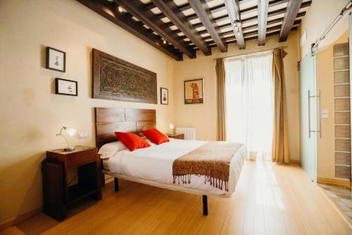 加的斯Loft del Arte的一间卧室配有一张带红色枕头的床和一扇窗户