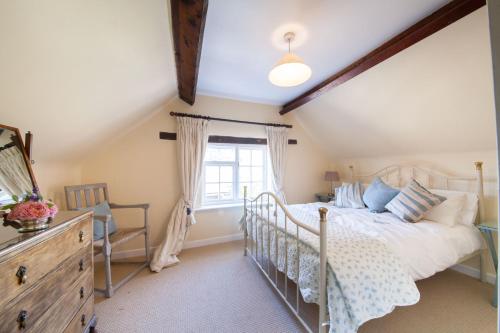 WortonPrince Hill Cottages的一间卧室配有一张床、一个梳妆台和一扇窗户。