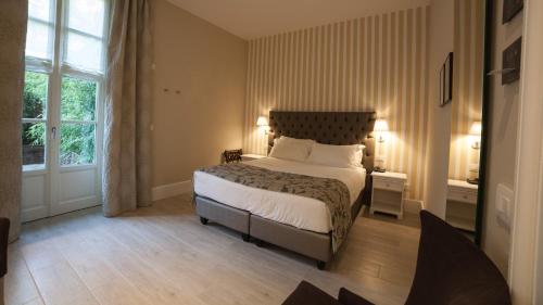 卡尼洛瑞维拉Park Hotel Italia的一间卧室配有一张带两盏灯的床和一扇窗户。