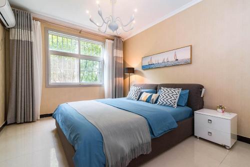 洛阳河南省洛阳市·南湖音乐喷泉广场·路客精品公寓·00131790的一间卧室配有一张带蓝色床单的床和一扇窗户。