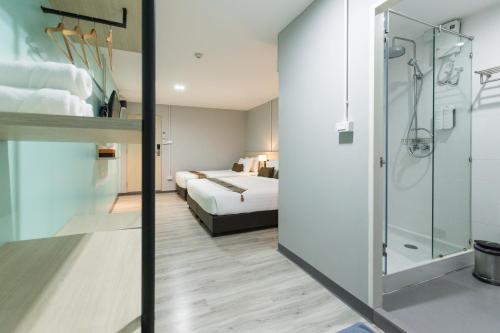 曼谷暹罗体育场旅舍的酒店客房带一张床和一个玻璃淋浴间