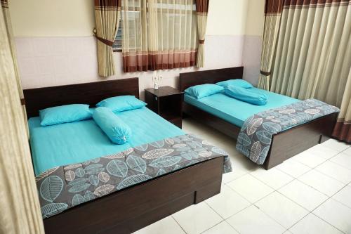 巴图Villa Cemara的两张带蓝色枕头的床