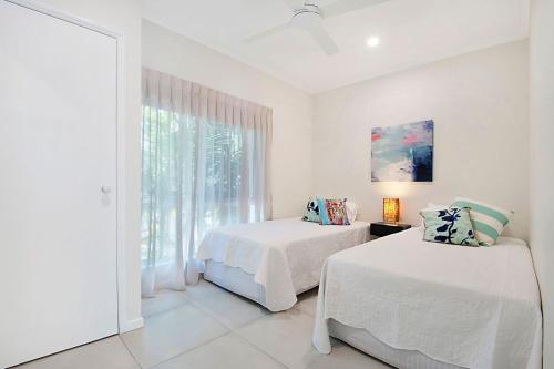 努萨维尔Durramboi Luxury Apartment的一间白色卧室,配有两张床和窗户