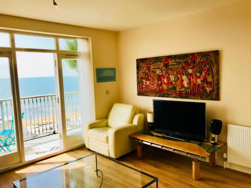 文特诺'Kaia' Beach Vista, Ventnor Beach的客厅配有平面电视和沙发。