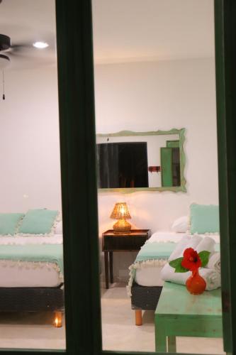 图卢姆波萨达蓬彼德拉海滩酒店的一间卧室配有两张床和一张带镜子的桌子