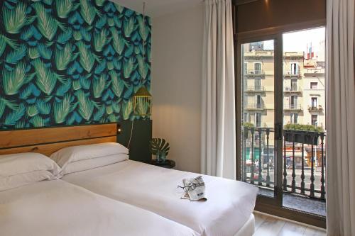 巴塞罗那Chic & Basic Lemon Boutique Hotel的一间卧室设有一张床和一个大窗户