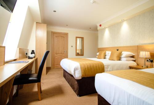 柯科迪维多利亚酒店的酒店客房配有两张床和一张书桌