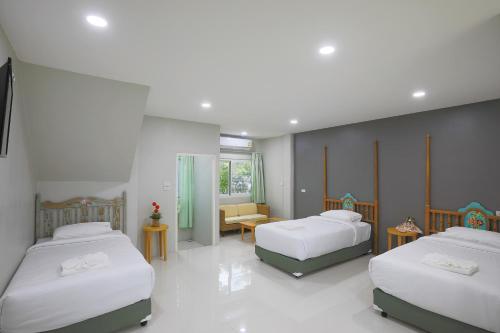 普吉镇Phuket Nonnita Boutique Resort - SHA Plus的一间卧室配有两张床和一张桌子及椅子