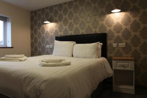伯明翰The Kingstanding Inn的一间卧室配有一张大床和两条毛巾