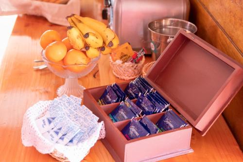 科伊艾科Hostal Los Teros的一张木桌,上面放着一盒食物和一碗水果