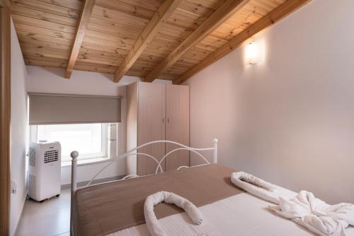 普拉塔尼亚斯Athina Apartments的配有木制天花板的客房内的白色床