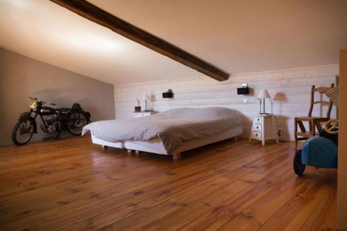 LandécourtLes Ruchers d'Emile的一间卧室配有一张床,铺有木地板