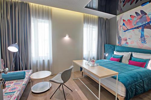 萨拉热窝FERHADIJA Apartments by Nejra的一间卧室配有一张床、一张桌子和一张沙发