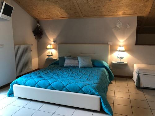 CandeloLa Mansarda Dell'Artista的一间卧室配有一张带蓝色被子的床和两盏灯。