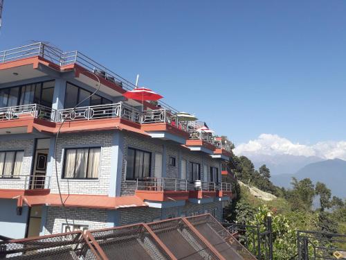 博卡拉Himalayan crown lodge的山顶上带阳台的建筑
