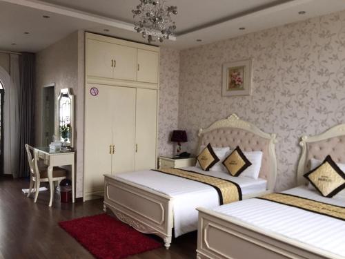 土龙木市比德科酒店的一间卧室配有两张床、一张桌子和一张书桌